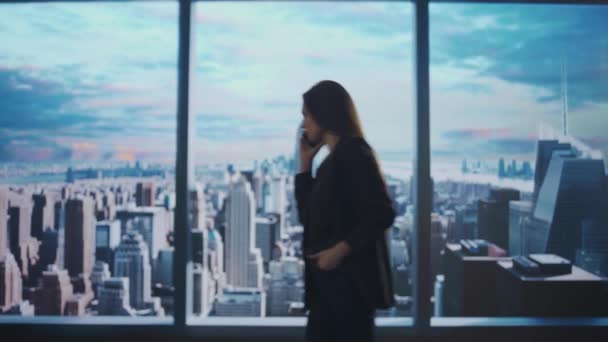 企業のビジネス広告コンセプト オフィスで成功したビジネス女性 女性の天井ヘッジファンドトップマネージャーが朝の街の景色と窓の前にスマートフォンで主張 — ストック動画