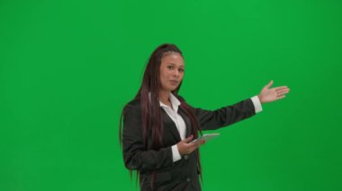 TV haber bülteni canlı yayın reklam konsepti. Krom anahtar yeşil ekran arka planında izole edilmiş kadın muhabir. Afro-Amerikalı kadın haber sunucusu, tabletle konuşuyor..