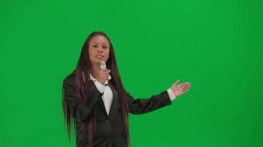 TV haber bülteni ve canlı yayın reklam konsepti. Krom anahtar yeşil ekran arka planında izole edilmiş kadın muhabir. Afrika kökenli Amerikalı kadın sunucu mikrofonla konuşuyor..