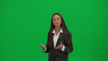 TV haber bülteni ve canlı yayın reklam konsepti. Krom anahtar yeşil ekran arka planında izole edilmiş kadın muhabir. Afrika kökenli Amerikalı kadın haber sunucusu boş alanı işaret ederek konuşuyor..