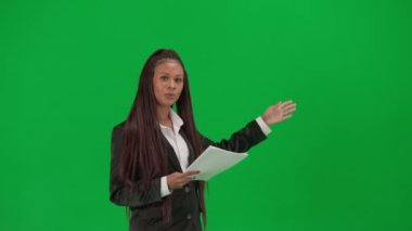 TV haber bülteni canlı yayın reklam konsepti. Krom anahtar yeşil ekran arka planında izole edilmiş kadın muhabir. Afrika kökenli Amerikalı kadın haber sunucusu elinde kağıt belgelerle kamerada konuşuyor..
