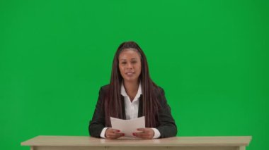 TV haber bülteni ve canlı yayın reklam konsepti. Krom anahtar yeşil ekran arka planında izole edilmiş kadın muhabir. Takım elbiseli Afrikalı Amerikalı kadın haber sunucusu belgeler okuyor ve konuşuyor..