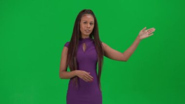 TV haber bülteni ve canlı yayın reklam konsepti. Krom anahtar yeşil ekran arka planında izole edilmiş kadın muhabir. Afrika kökenli Amerikalı kadın haber sunucusu boş alanı işaret ederek konuşuyor.