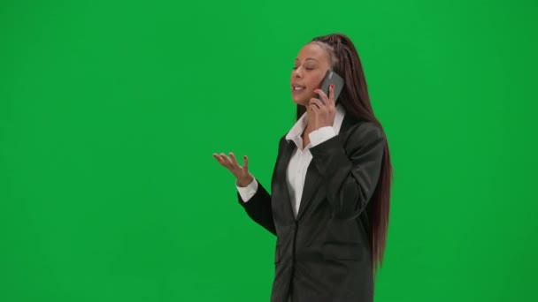テレビニュースレポートとライブ放送広告コンセプト クロマキーの緑色の背景で隔離された女性の記者は アフリカ系アメリカ人女性ニュースホストが歩いてスマートフォンで話す — ストック動画