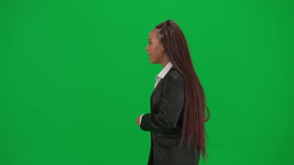 电视新闻报道和现场直播广告的概念 女性记者在彩色键绿色屏幕背景上被隔离 非裔美国妇女新闻主持人穿着西装走路和说话 — 图库视频影像
