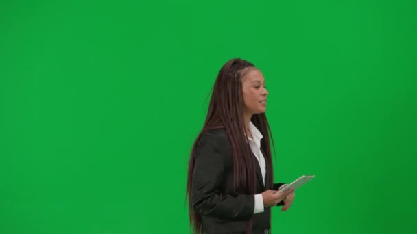 テレビニュースレポートライブ放送広告コンセプト クロマキーの緑色の背景で隔離された女性の記者は アフリカ系アメリカ人女性のニュースホストがタブレットで話すショーは空の領域を示しています — ストック動画