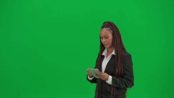 电视新闻现场直播广告的概念 女性记者在彩色键绿色屏幕背景上被隔离 身穿平板电脑脱口秀服的非洲裔美国女主持人 — 图库视频影像