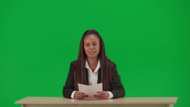 电视新闻报道和现场直播广告的概念 女性记者在彩色键绿色屏幕背景上被隔离 穿着西装 阅读文件和说话的非裔美国女性新闻主持人 — 图库视频影像