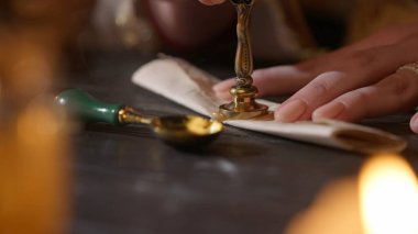 Tarihi harf yaratıcı konsept. Antika elbiseli bir kadın mektup pulu yapıyor. Kapalı çekim kadın rulo kağıt zarf ile balmumu ve altın mühür ile mektup.