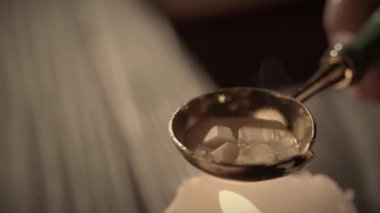 Eski bir harf yaratıcı kavramı. Yaşlı bir kaşık tutan kadın. Yakından çekilen bir kadın, mumdaki eski altın kaşıkta balmumunu ısıtıyor. Eski pullu mühürlü mektup için hazırlanıyor..