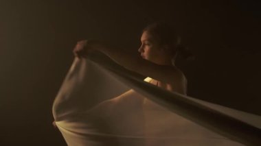 Dansın özü ışığın ve gölgenin narin etkileşiminde, beyaz şifonla sarılmış bir dansçı gibi özgüvenle hareket eder. İnce ışıklandırma dansçıların hareketinin akıcılığının ve zarafetinin altını çiziyor.