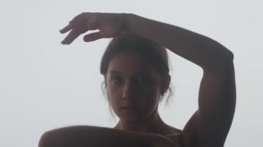 Genç dansçı, çağdaş dansı ile derin duygular ifade eder. Yumuşak ışıkla vurgulanmış silueti, hareketlerinin zarafetini ve zarafetini yansıtıyor..