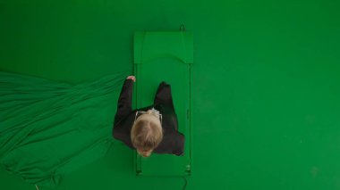 Modern iş kadını yaratıcı reklam konsepti. Krom anahtar yeşil ekranda takım elbiseli kadın portresi. Resmi kıyafet giymiş sarışın iş kadını. Üst görünüm.