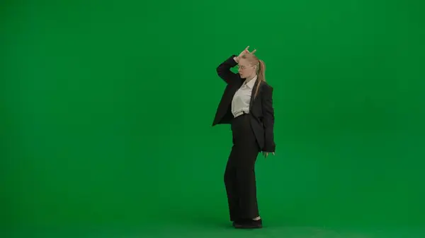 穿着黑色西服的女人带着铬钥匙欢快地在绿色屏幕上跳舞 现代女商人创意广告概念 — 图库照片