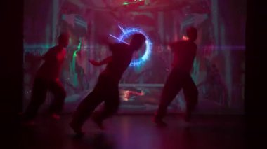 Büyük bir LED ekranın parıltısıyla yıkanan modern bir stüdyoda, üç dansçı, iki kadın ve bir erkek hip-hop yeteneklerini sergiliyorlar. Arkalarındaki ekran canlı dinamik arkaplanlarla titreşiyor..