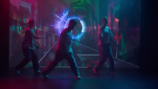 在一个发光发光的Led屏幕的现代工作室里 三位舞者 两名女性和一名男性展示了他们的嘻哈技巧 他们身后的屏幕闪烁着充满活力的动态背景 — 图库视频影像
