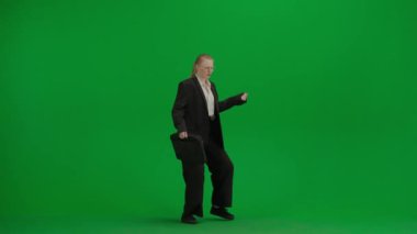 Modern iş kadını yaratıcı reklam konsepti. Krom anahtar yeşil ekranda takım elbiseli kadın portresi. Resmi kıyafetli, evrak çantalı sarışın iş kadını etrafına bakar ve dans etmeye başlar..