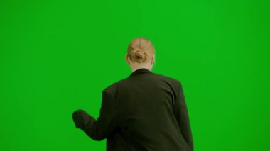 Modern iş kadını yaratıcı reklam konsepti. Krom anahtar yeşil ekranda takım elbiseli kadın portresi. Resmi kıyafet giymiş, yürüyüş ve dans eden sarışın iş kadını. Arka plan.