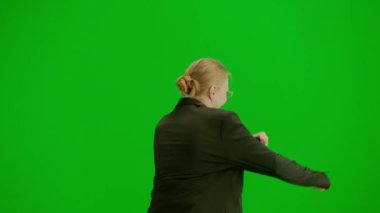 Modern iş kadını yaratıcı reklam konsepti. Krom anahtar yeşil ekranda takım elbiseli kadın portresi. Resmi kıyafet giymiş, yürüyüş ve dans eden sarışın iş kadını. Arka plan.