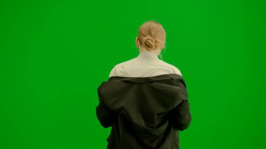 Modern iş kadını yaratıcı reklam konsepti. Krom anahtar yeşil ekranda takım elbiseli kadın portresi. Resmi kıyafetli sarışın iş kadını yürüyüş ve dans ediyor, gülümsüyor.