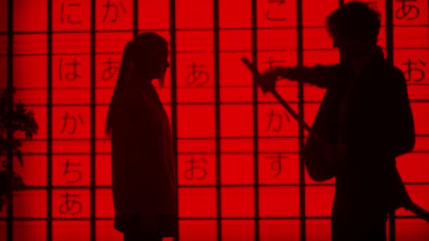 サイバーパンクビジュアルテクノロジークリエイティブコンセプト スタジオの大きなデジタル壁に反対する人々 デジタル画面の前に女性に日本の剣カタナを与える男のシルエット赤アジアのグラフィック背景 — ストック動画
