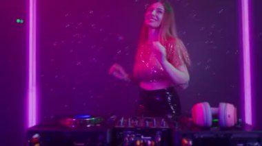 Gelecekçi siber punk teknolojisi konsepti. Dijital duvar renkli görsel arka planda çekici bir kadın. Genç kadın DJ dans ediyor, müzik karıştırıyor. Gece kulübünde piknik masaları karıştırıyor..