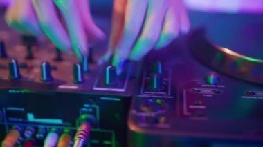 Gelecekçi siber punk teknolojisi konsepti. Müzik mikserinde kadın eli yakın çekim. Genç kadın DJ dans ediyor, müzik karıştırıyor. Gece kulübünde piknik masaları karıştırıyor..