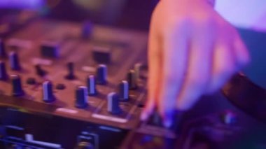 Gelecekçi siber punk teknolojisi konsepti. Müzik mikserinde kadın eli yakın çekim. Genç kadın DJ dans ediyor, müzik karıştırıyor. Gece kulübünde piknik masaları karıştırıyor..