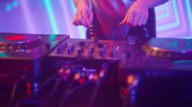 Gelecekçi siber punk teknolojisi konsepti. Müzik mikserinde kadın eli yakın çekim. Genç kadın DJ dans ediyor, müzik karıştırıyor. Gece kulübünde piknik masaları karıştırıyor..