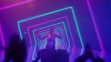 Gelecekçi siber punk teknolojisi konsepti. Dijital duvar renkli görsel arka planda çekici bir kadın. Genç kadın DJ dans ediyor, müzik karıştırıyor. Gece kulübündeki pikaplarda müzik çalıyor. Kalabalık vuruldu..