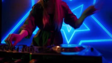 Gelecekçi siber punk teknolojisi konsepti. Dijital duvar renkli görsel arka planda çekici bir kadın. Maskeli genç kadın DJ dans ediyor, müzik karıştırıyor gece kulübünde pikaplarda müzik çalıyor..