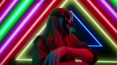 Gelecekçi siber punk teknolojisi konsepti. Dijital duvar renkli görsel arka planda çekici bir kadın. Maskeli genç kadın DJ dans ediyor, müzik karıştırıyor gece kulübünde pikaplarda müzik çalıyor..