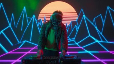 Gelecekçi siber punk teknolojisi konsepti. Dijital duvar renkli görsel arka planda çekici bir erkek. Maskeli genç adam dans ediyor, müzik karıştırıyor gece kulübünde pikaplarda müzik çalıyor..