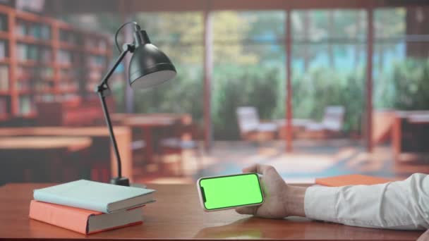 Ręce Człowieka Trzymającego Smartfona Zielonym Kluczem Chromowym Ciepłe Tło Biblioteki — Wideo stockowe