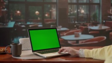 Yeşil ekranlı bir dizüstü bilgisayarda çalışan bir kadın. Büyük pencereli kafede akşam yemeği. Metin veya resim için şablon yeri, promosyon içeriği. Reklam alanı, çalışma alanı maketi