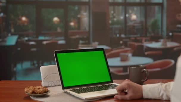 Чоловік Працює Ноутбуці Зеленим Екраном Вечірня Обстановка Кафе Великими Вікнами — стокове відео