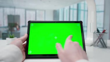 Bir iş kadını elleri tablet yeşil krom anahtar ekranla etkileşime girer. Pencereleri olan parlak bir ofis. Metin veya resim için şablon yeri, promosyon içeriği. Reklam alanı, çalışma alanı maketi.
