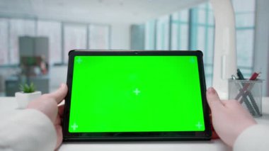Bir iş kadını elleri tablet yeşil krom anahtar ekranla etkileşime girer. Pencereleri olan parlak bir ofis. Metin veya resim için şablon yeri, promosyon içeriği. Reklam alanı, çalışma alanı maketi.