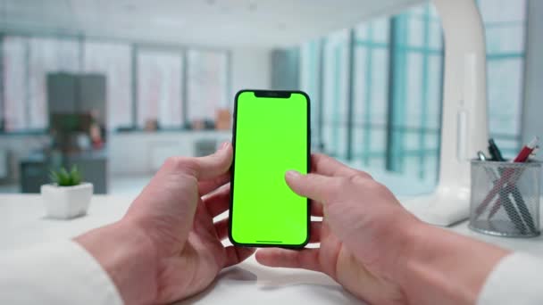 Mans手与智能手机绿色屏幕彩色键交互 有窗户的明亮的办公室 模板的位置为您的文字或形象 促销内容 广告区 模拟工作区 — 图库视频影像
