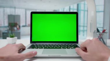 İş adamı yeşil ekranlı dizüstü bilgisayarla görüntülü konuşuyor. Pencereleri olan parlak bir ofis. Metin veya resim için şablon yeri, promosyon içeriği. Reklam alanı, çalışma alanı maketi