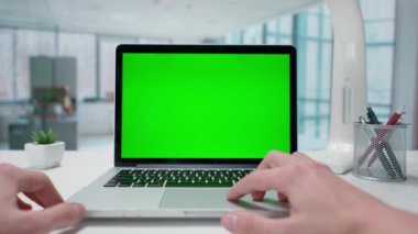 Yeşil ekranlı bir dizüstü bilgisayarda çalışan bir iş adamı. Pencereleri olan parlak bir ofis. Metin veya resim için şablon yeri, promosyon içeriği. Reklam alanı, çalışma alanı maketi