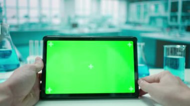 Bir erkek doktor yeşil ekran krom anahtarı olan bir tabletle ilgili bilgiye bakıyor. Soğuk mavi laboratuvar geçmişi. Metin veya resim için şablon yeri, promosyon içeriği. Reklam alanı.