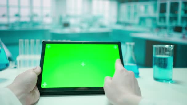 一个女人的手与一个平板绿色的彩色键屏相互作用 冷蓝色实验室背景 模板的位置为您的文字或形象 促销内容 广告区 模拟工作区 — 图库视频影像