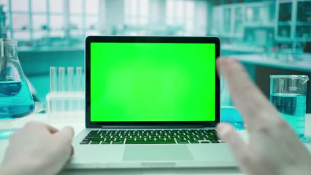 女性医師は 緑色のクロマキーでラップトップを使用してビデオ通話を介して通信します コールドブルーラボの背景 テキストや画像 プロモーションコンテンツのテンプレート 広告エリア — ストック動画
