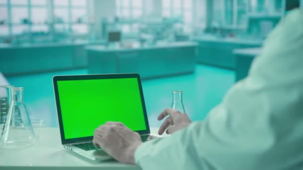 男医生用绿色屏幕彩色键在键盘笔记本电脑上打字 冷蓝色实验室背景 模板的位置为您的文字或形象 促销内容 广告领域 — 图库视频影像