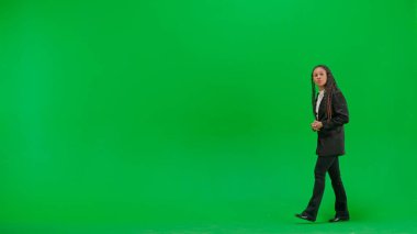 Televizyon haberleri ve canlı yayın konsepti. Genç bayan muhabir krom anahtar yeşil ekran arka planında izole edildi. Tam teşekküllü Afro-Amerikan kadın televizyon sunucusu ciddi bir suratla konuşuyor..