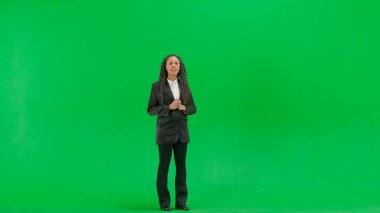 Televizyon haberleri ve canlı yayın konsepti. Genç bayan muhabir krom anahtar yeşil ekran arka planında izole edildi. Afro-Amerikan kadın TV sunucusu kameraya bakarak konuşuyor..