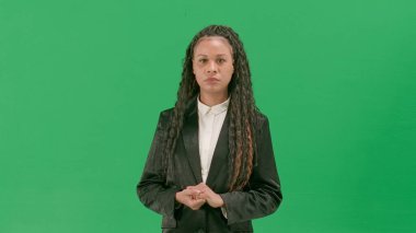Televizyon haberleri ve canlı yayın konsepti. Genç bayan muhabir krom anahtar yeşil ekran arka planında izole edildi. Afrika kökenli Amerikalı kadın televizyon sunucusu ciddi bir suratla konuşuyor..