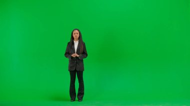 Televizyon haberleri ve canlı yayın konsepti. Genç bayan muhabir krom anahtar yeşil ekran arka planında izole edildi. Tam teşekküllü Afro-Amerikan kadın televizyon sunucusu ciddi bir suratla konuşuyor..