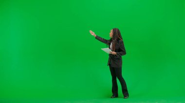 Televizyon haberleri ve canlı yayın konsepti. Genç bayan muhabir krom anahtar yeşil ekran arka planında izole edildi. Tam teşekküllü Afro-Amerikan kadın TV haber sunucusu. Gazeteler konuşuyor ve yürüyor..